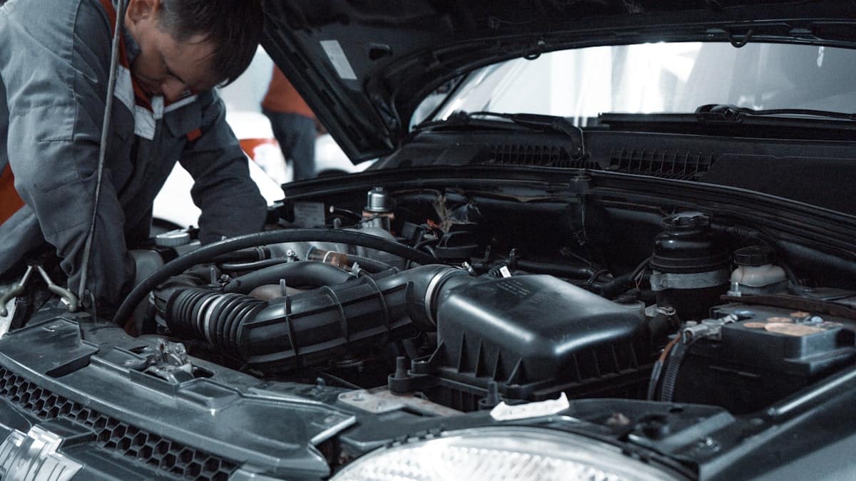 Açık kaput altında motoru inceleyen ekspertiz teknisyeni