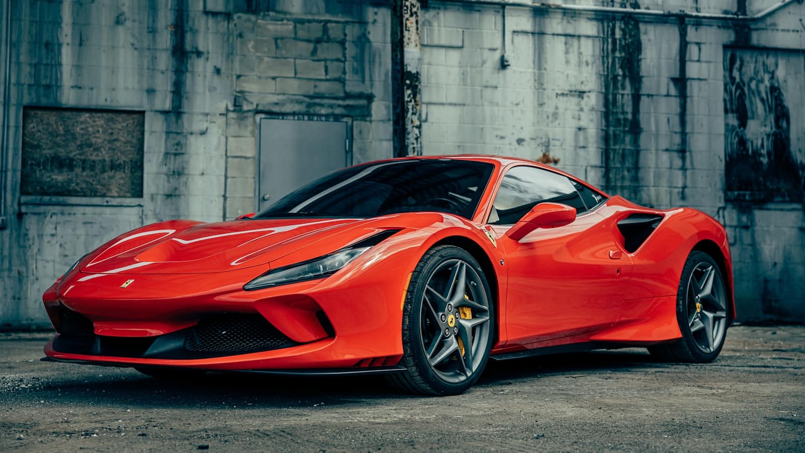 Endüstriyel beton duvar önünde kırmızı Ferrari F8 Tributo