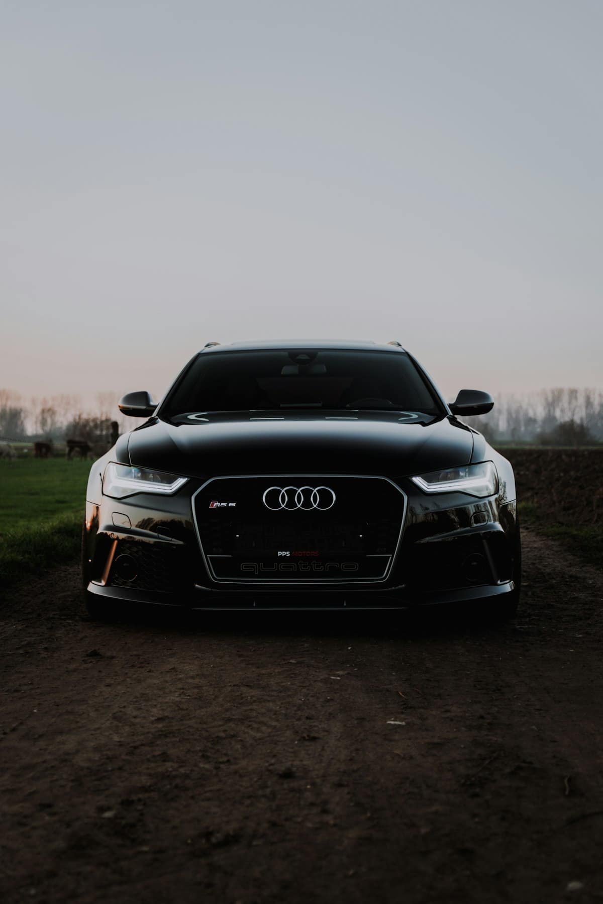 Alacakaranlıkta siyah Audi RS6 Avant, önden simetrik açı